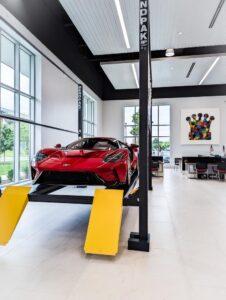 Ein roter Sportwagen (Ferrari) ist in einem Showroom ausgestellt