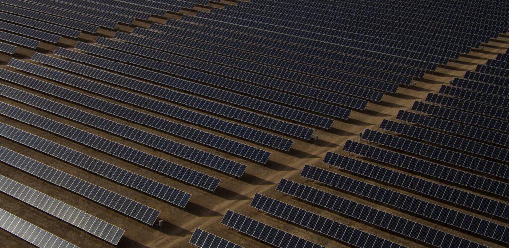 Luftaufnahme einer großen Photovoltaikanlage in Dortmund bei Sonnenuntergang, zeigt die umfangreiche Nutzung von Solarenergie zur nachhaltigen Stromerzeugung in der Stadt.