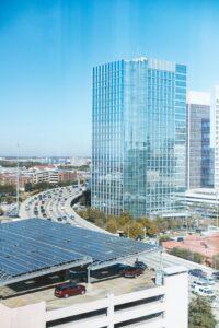 Moderne Photovoltaikanlage auf dem Dach eines Parkhauses in Dortmund, mit Blick auf ein Hochhaus und eine belebte Straße, zeigt die Integration von Solarenergie in urbanen Bereichen.