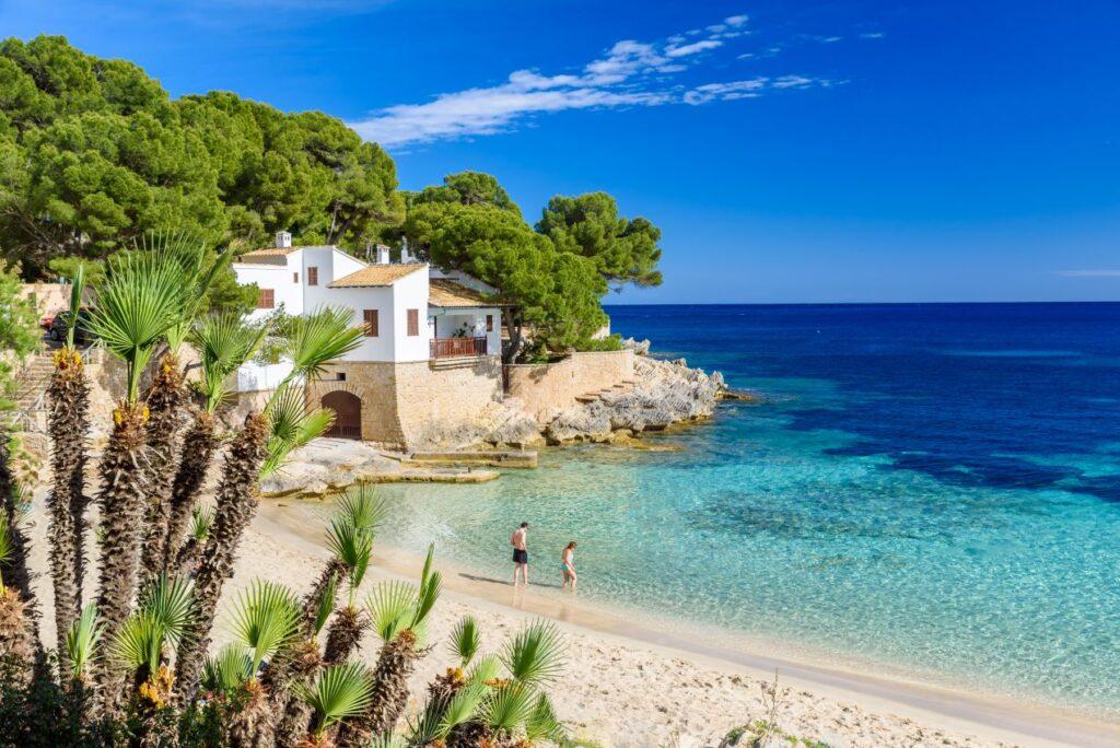 Weißes Ferienhaus direkt am Strand Sardinien, umgeben von Pinien, mit Blick auf das türkisfarbene Meer