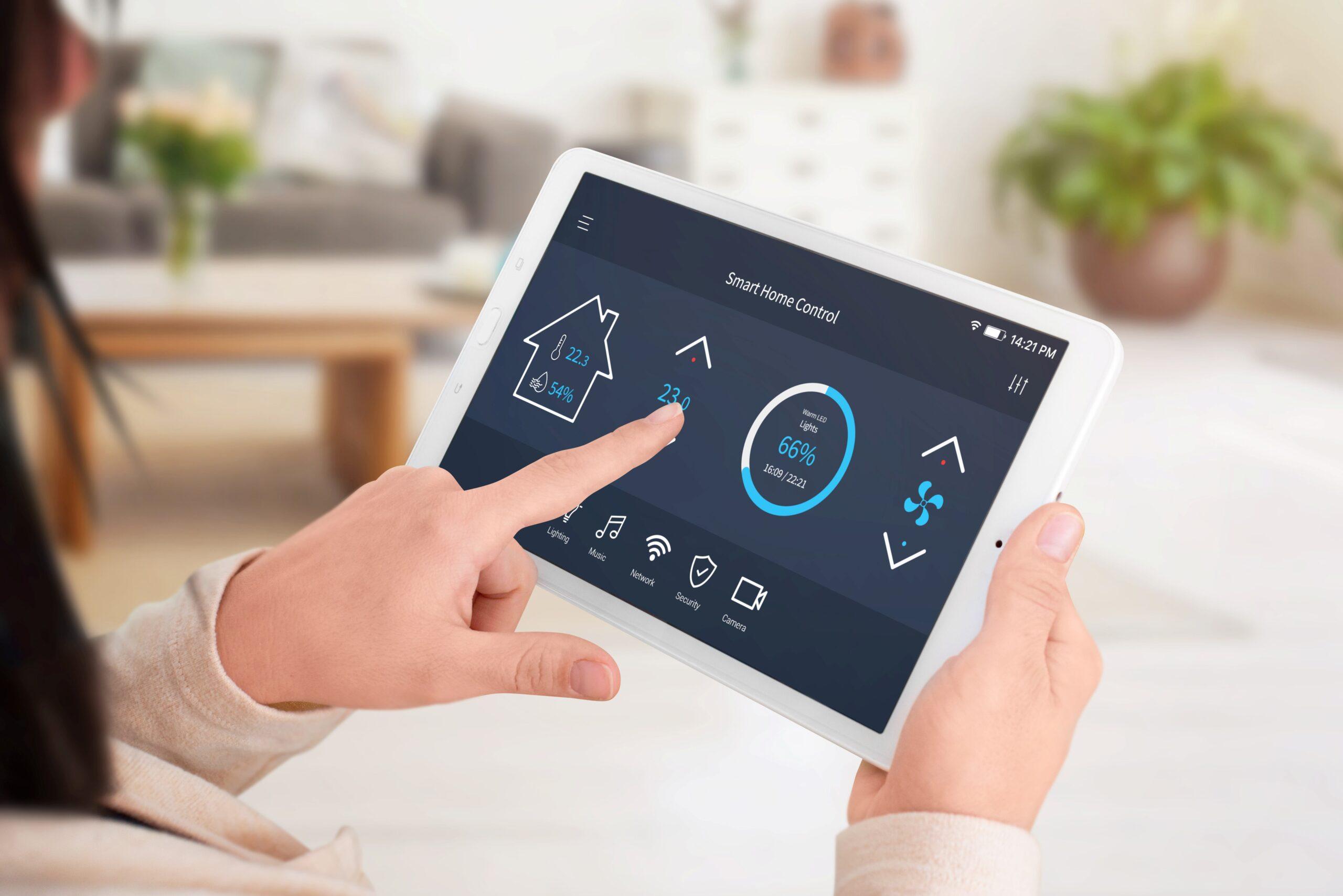 Moderne Software zur Heimsteuerung auf dem Tablet-Display. Frau kontrolliert die Temperatur im Wohnzimmer. Nahaufnahme.