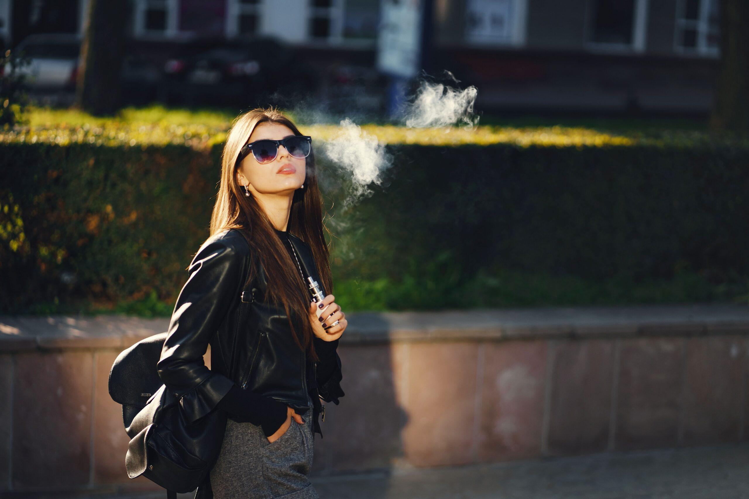 Frau mit E-Zigarette in der Sonne