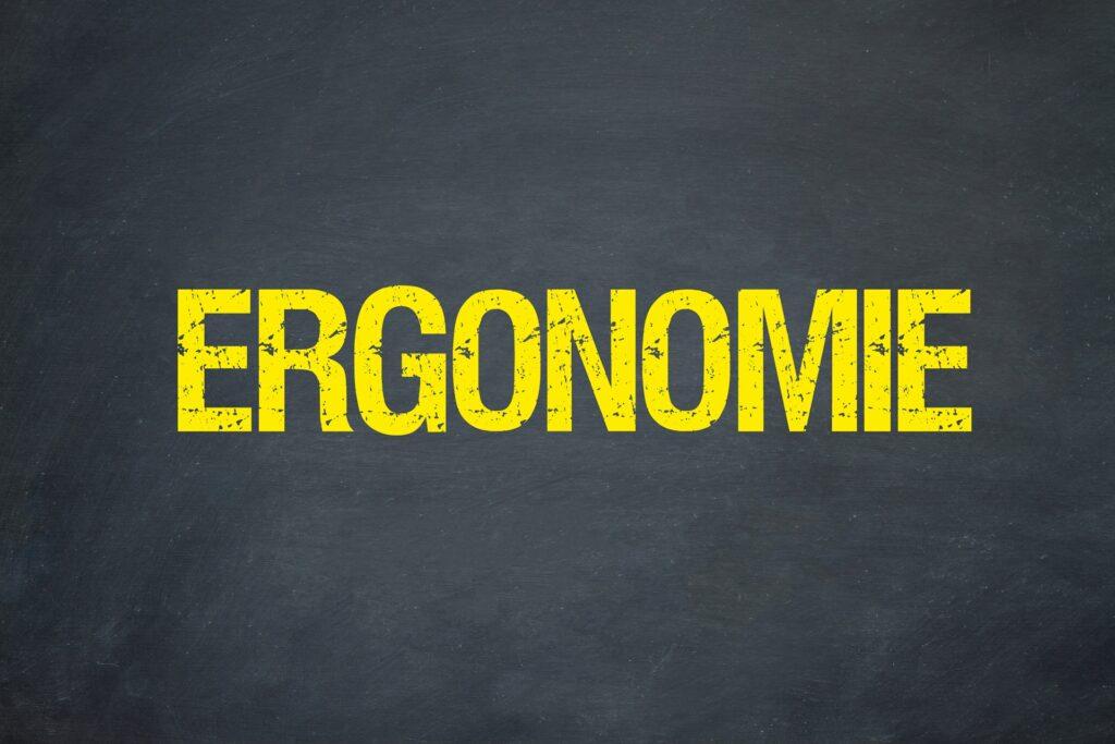 Gelber Ergonomie-Schriftzug auf dunklem Hintergrund | Chiropraxis Berlin